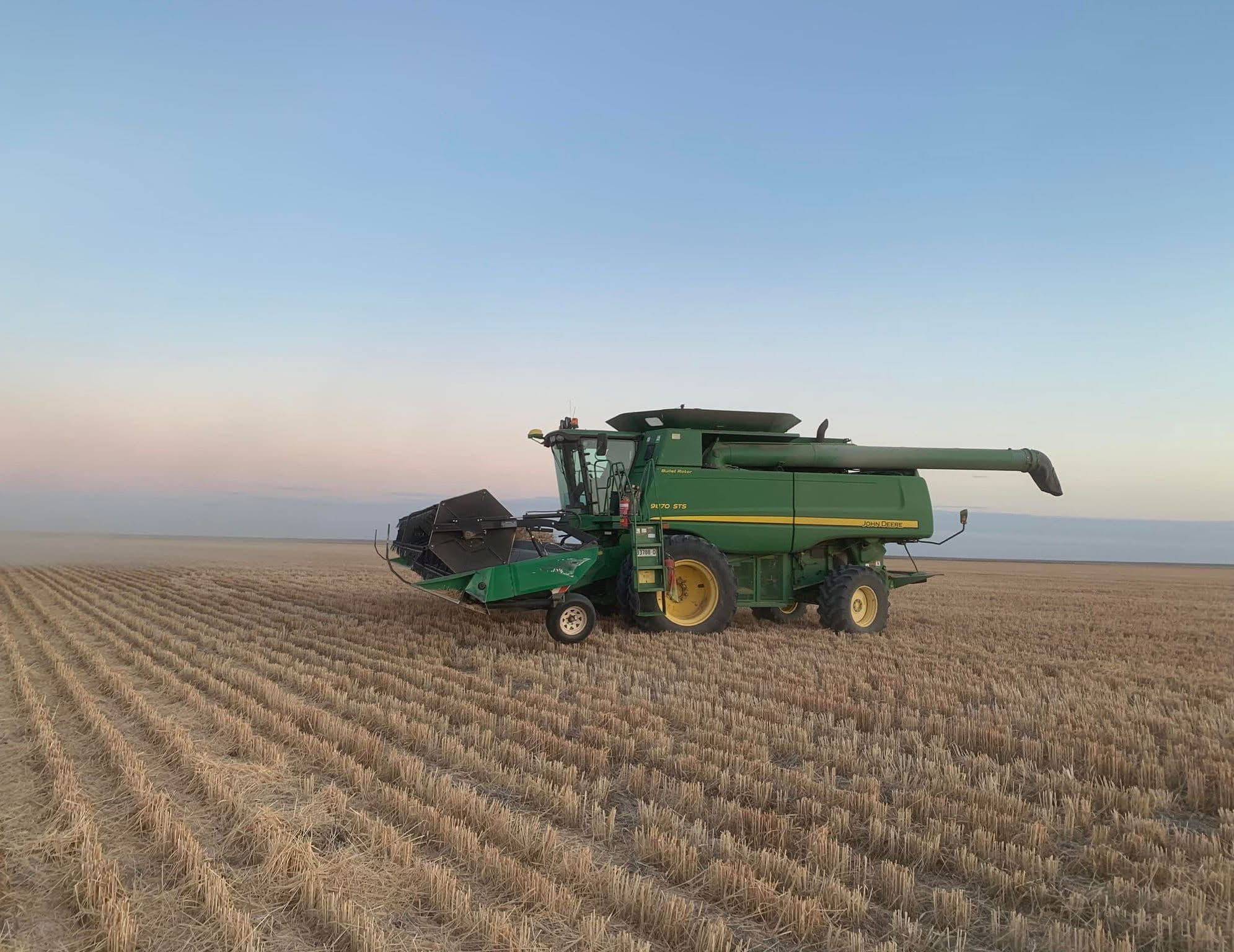 John Deere combine harvester at dusk — agricultural finance